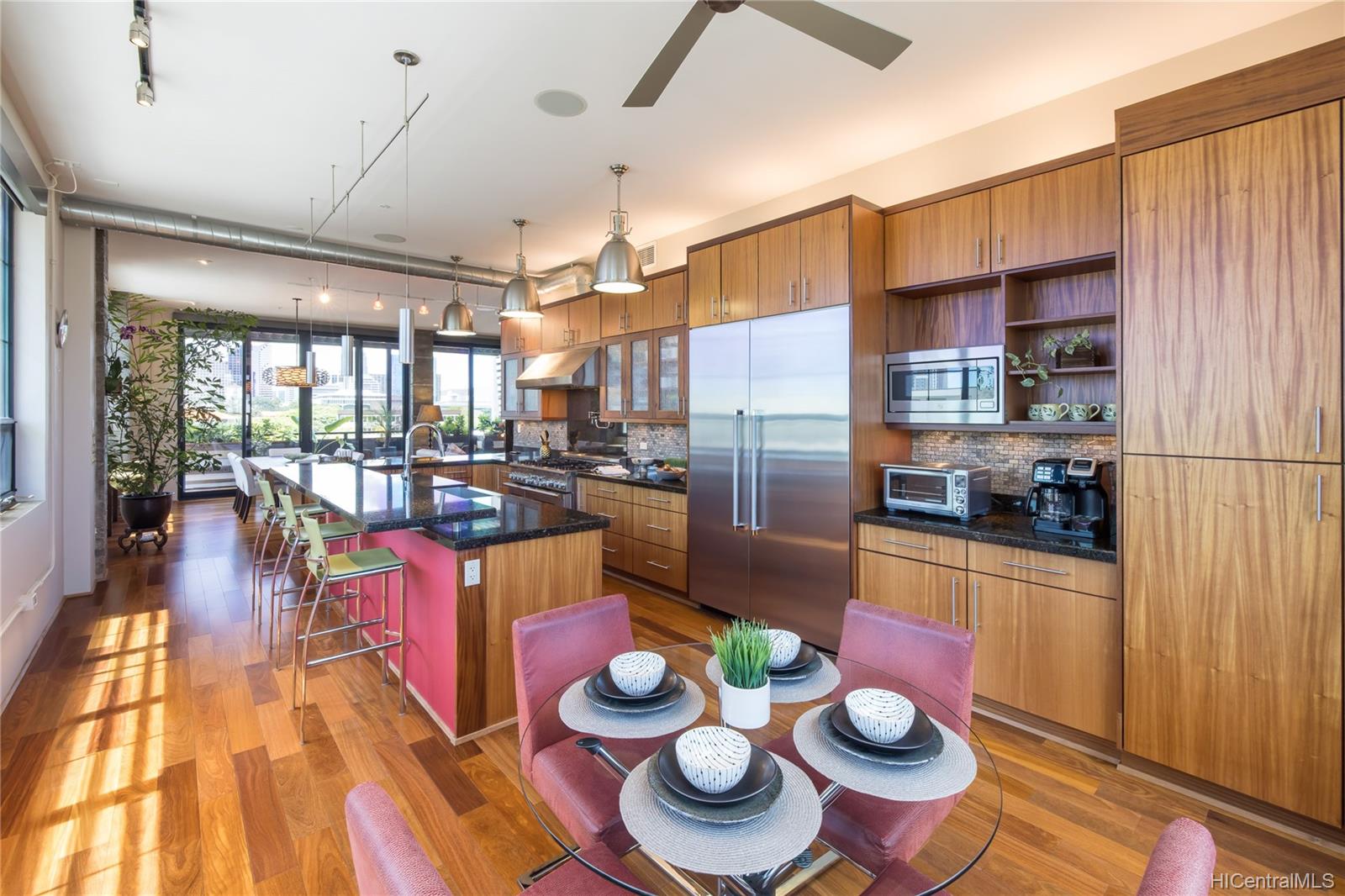 A modern kitchen with stainless steel appliances and wood cabinetry in the Vanguard Lofts Hawaii 501